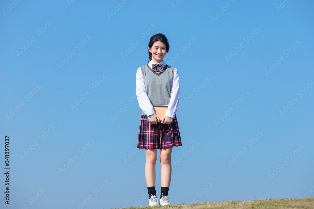 Asian female students against blue sky background