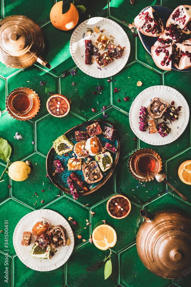 Flat-lay of variety of Turkish traditional lokum sweet delight with Turkish tea in copper pots and t