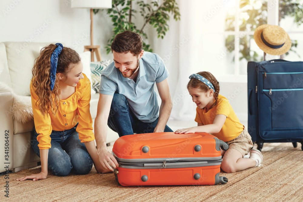 Happy parents with daughter with suitcase setting off for journey.