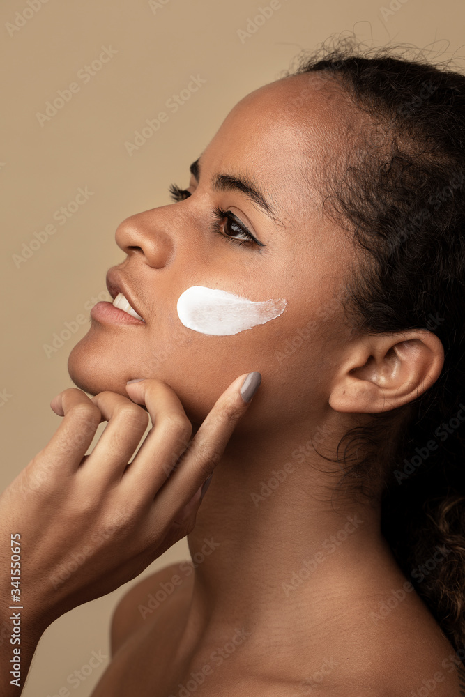 Woman applying moisturizing cream for skincare