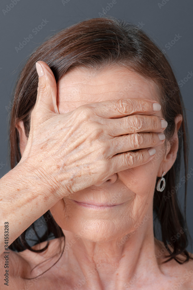 Close up of a senior woman covering her eyes