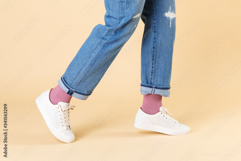 Woman wearing jeans and white sneakers