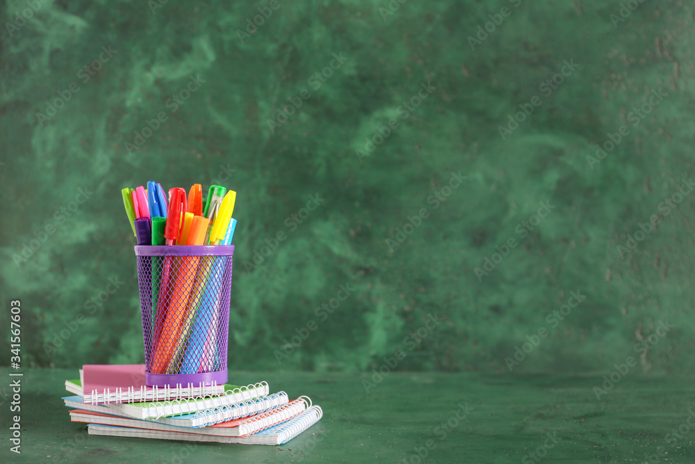 Holder with stationery on color background