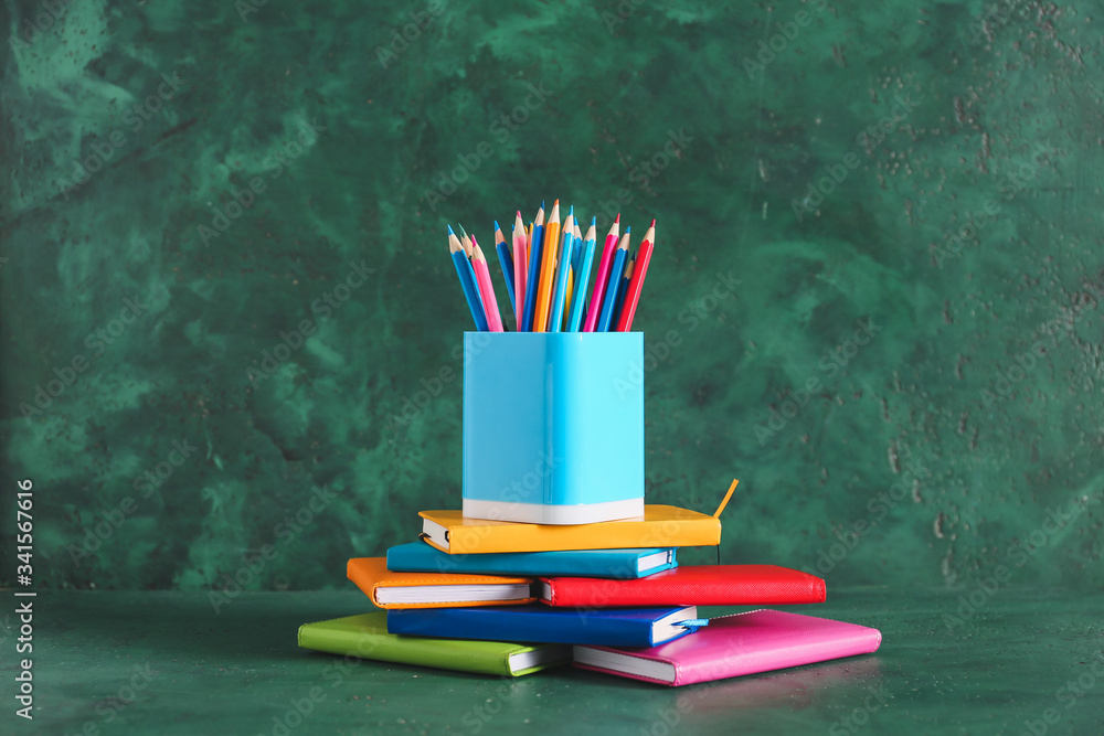 Holder with stationery on color background