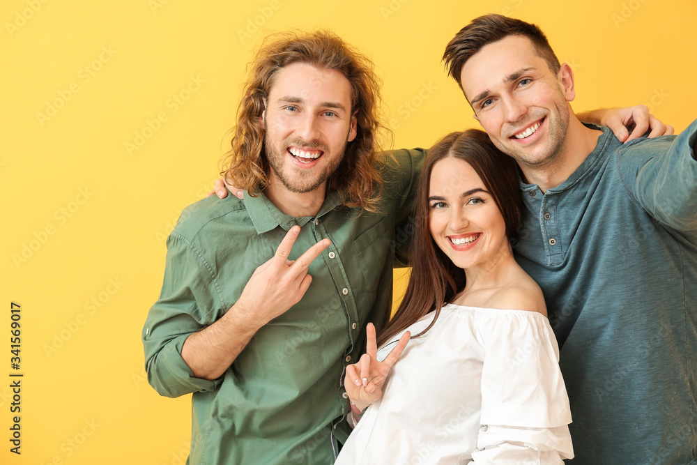 Friends taking selfie on color background