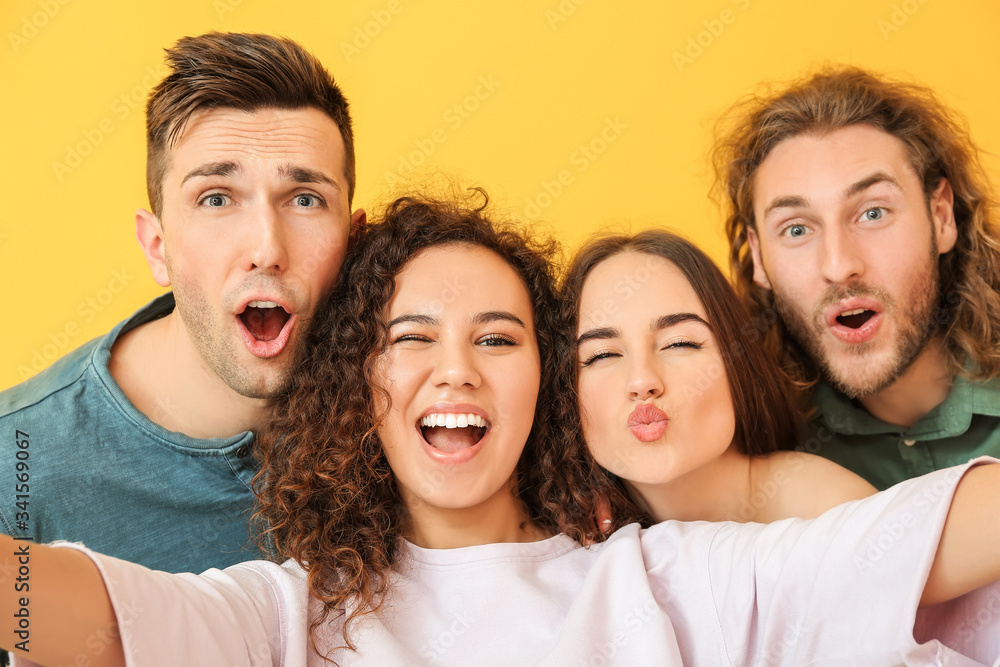 Friends taking selfie on color background