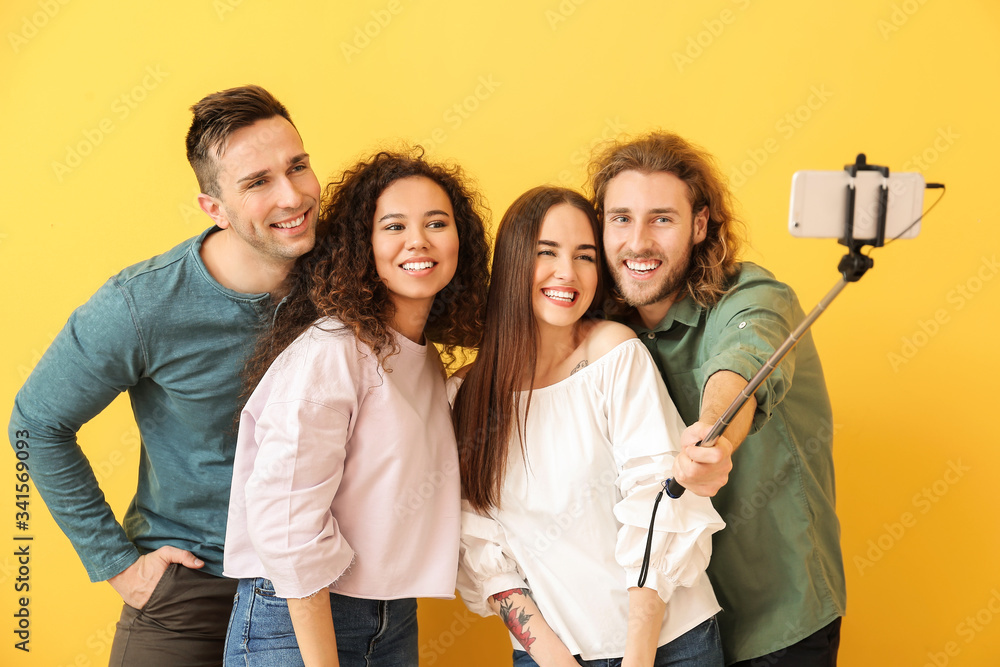 Friends taking selfie on color background