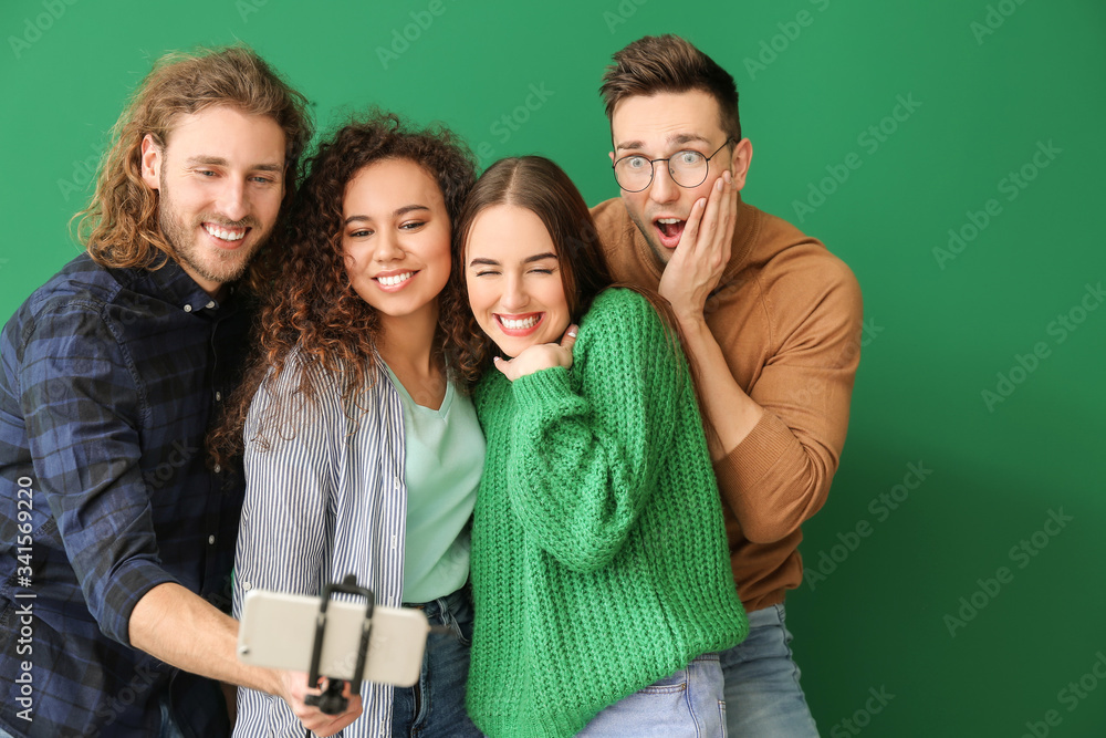 Friends taking selfie on color background