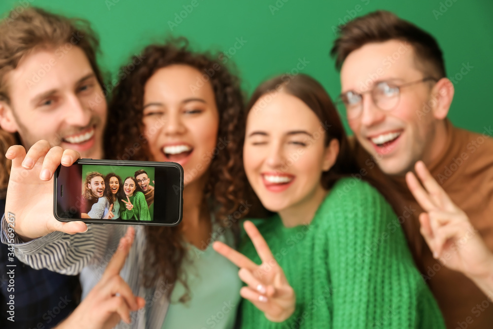 Friends taking selfie on color background