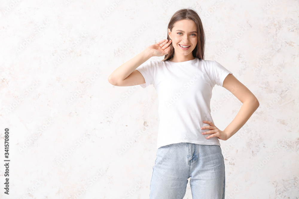 Young woman in stylish t-shirt on light background