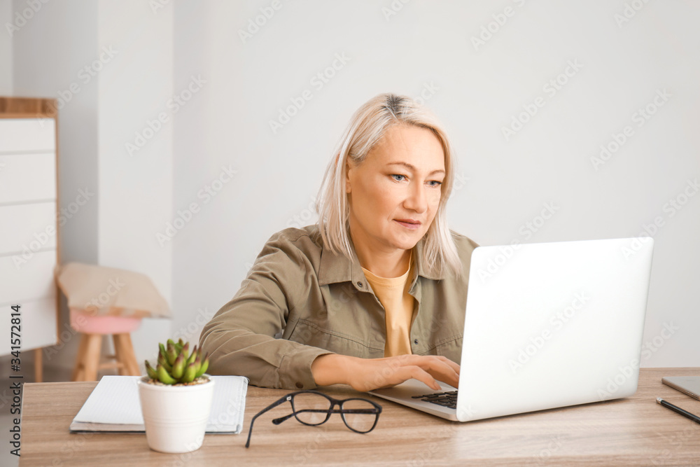 Mature woman using laptop for online learning at home