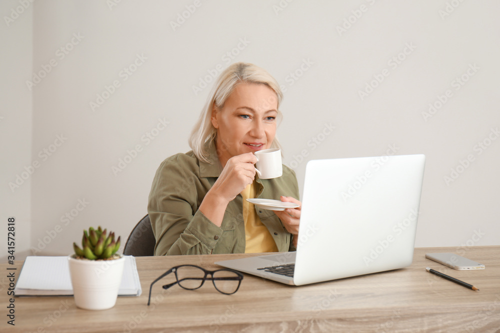 Mature woman using laptop for online learning at home