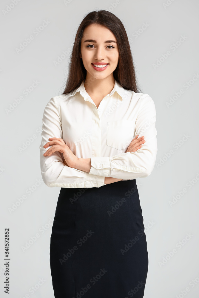 Portrait of beautiful young businesswoman on light background