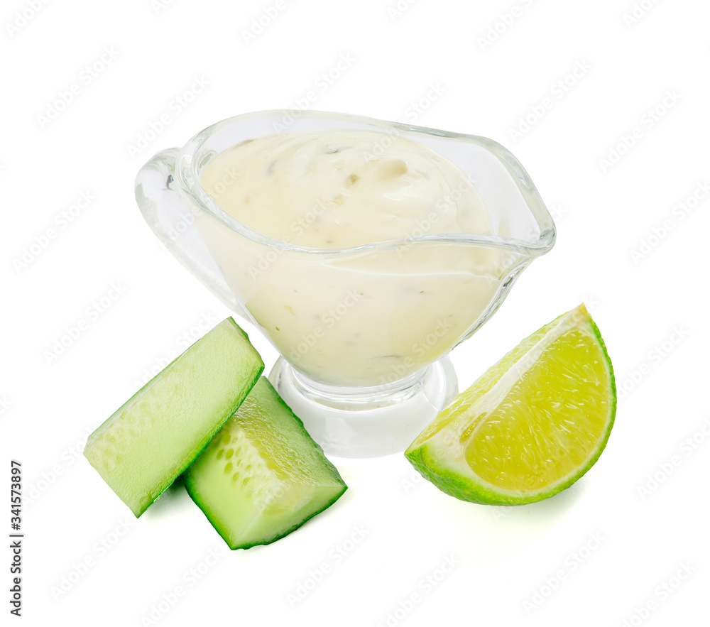 Delicious yogurt sauce with cucumber in gravy boat on white background