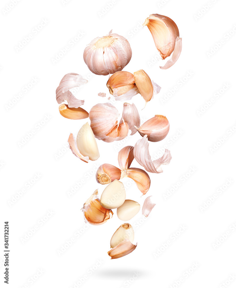 Garlic cloves are falling down closeup, isolated on a white background