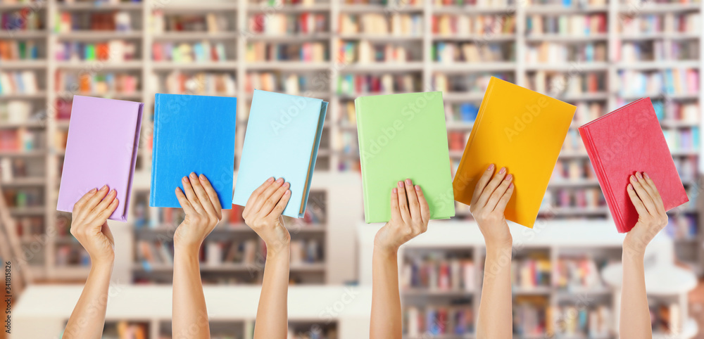 Female hands with books in modern library