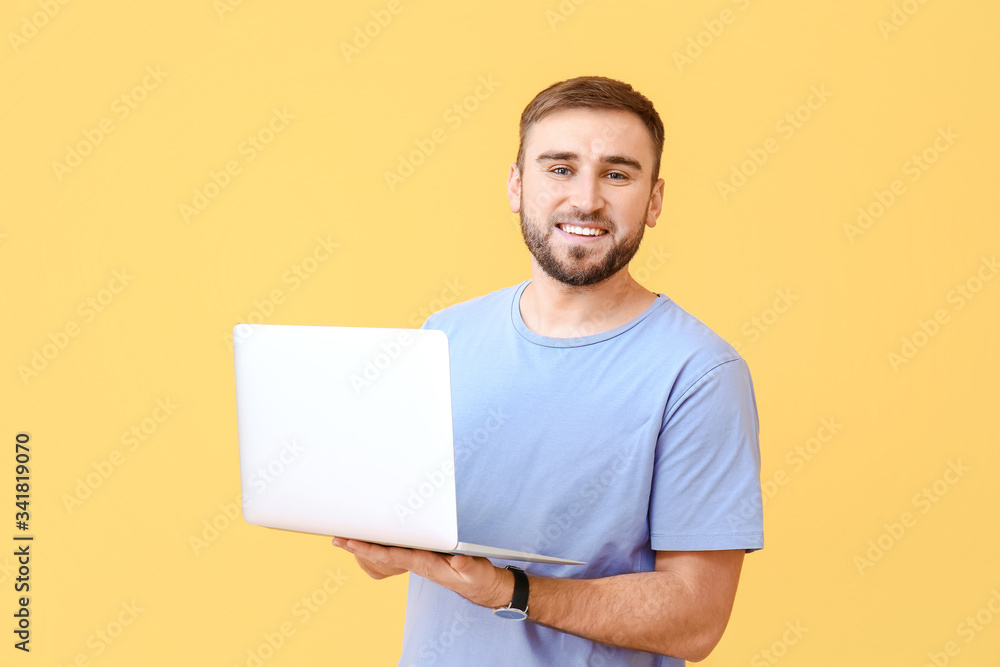 Male programmer with laptop on color background