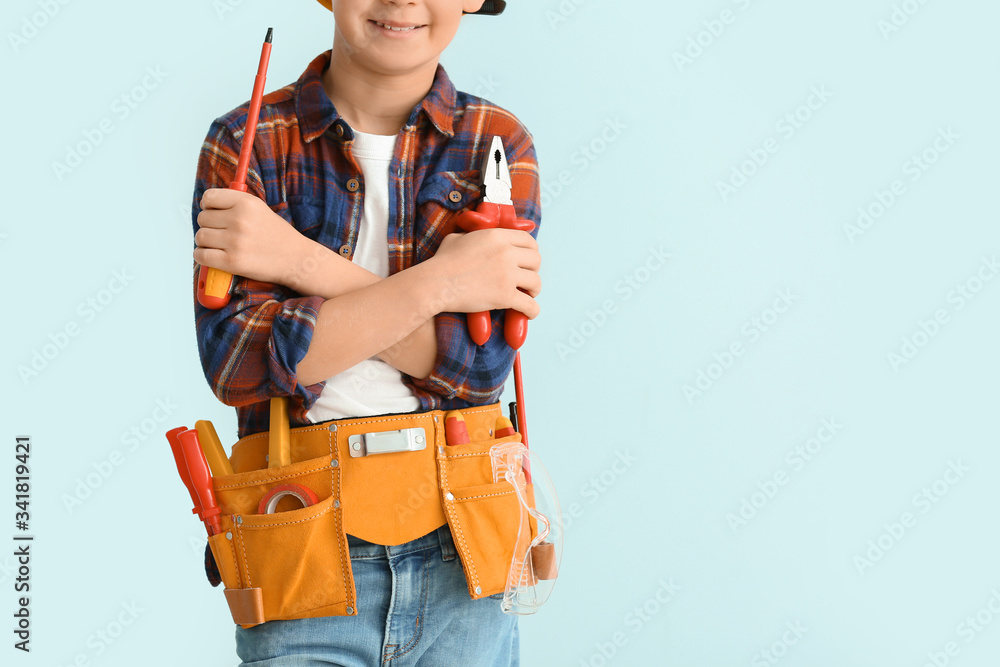 Cute little electrician on color background