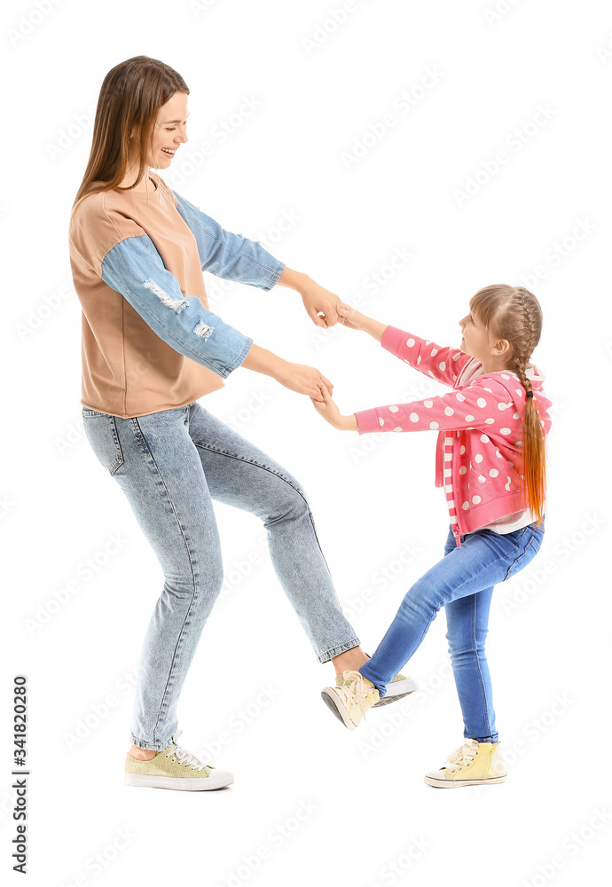 Happy mother and her little daughter dancing against white background