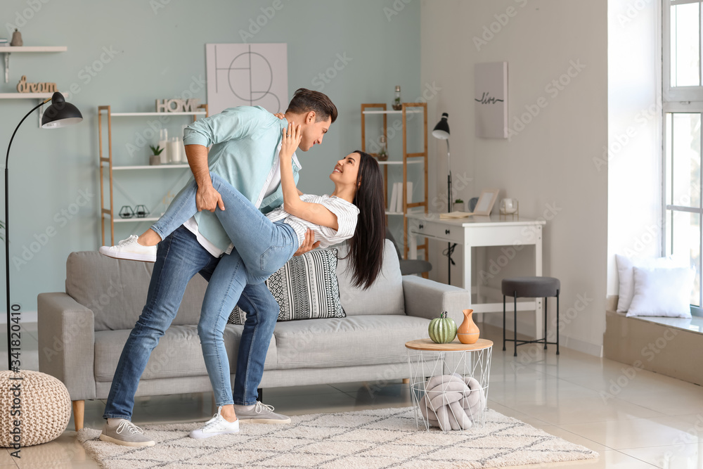 Happy young couple dancing at home