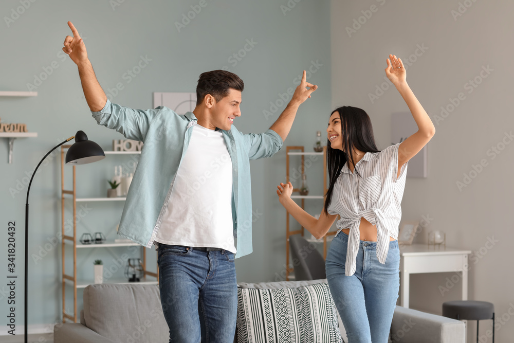 Happy young couple dancing at home