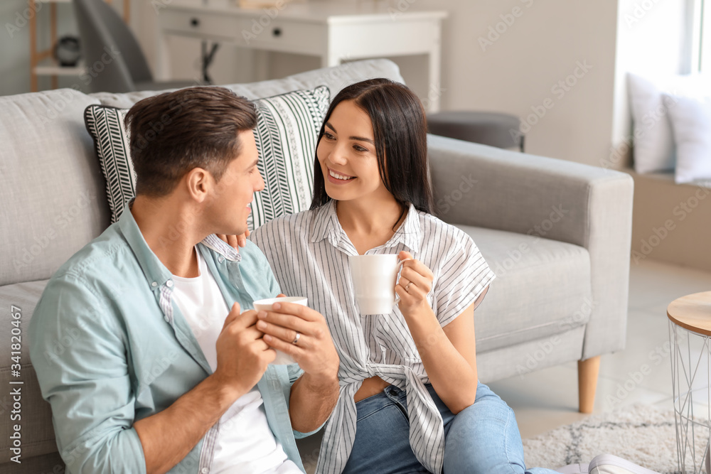 Happy young couple drinking tea at home