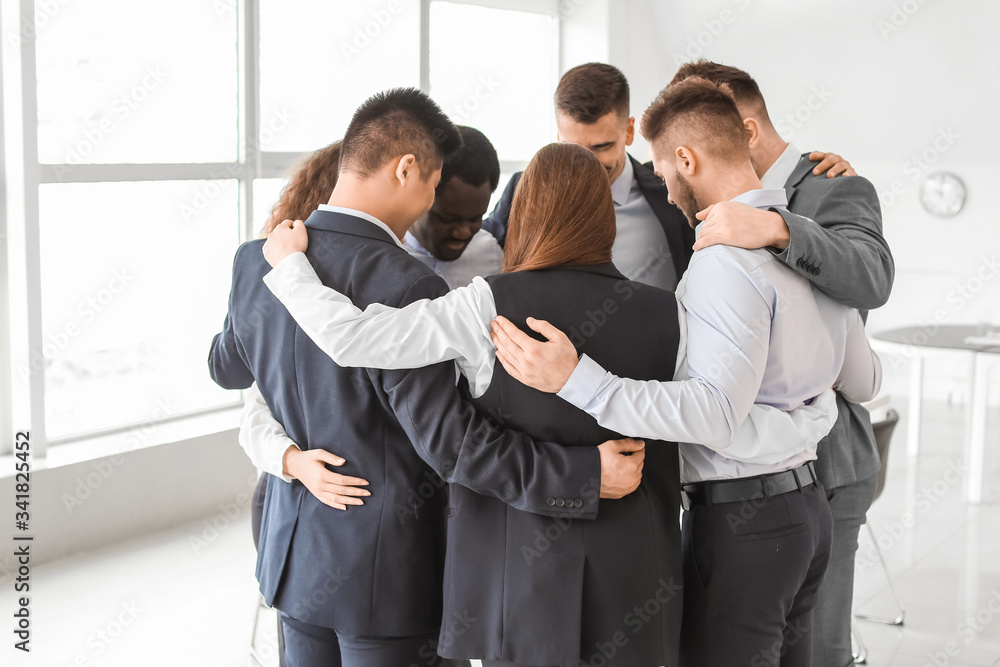 Group of business people hugging in office. Unity concept