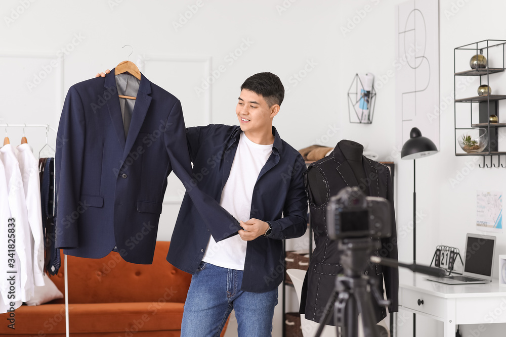 Male Asian stylist recording video in his studio