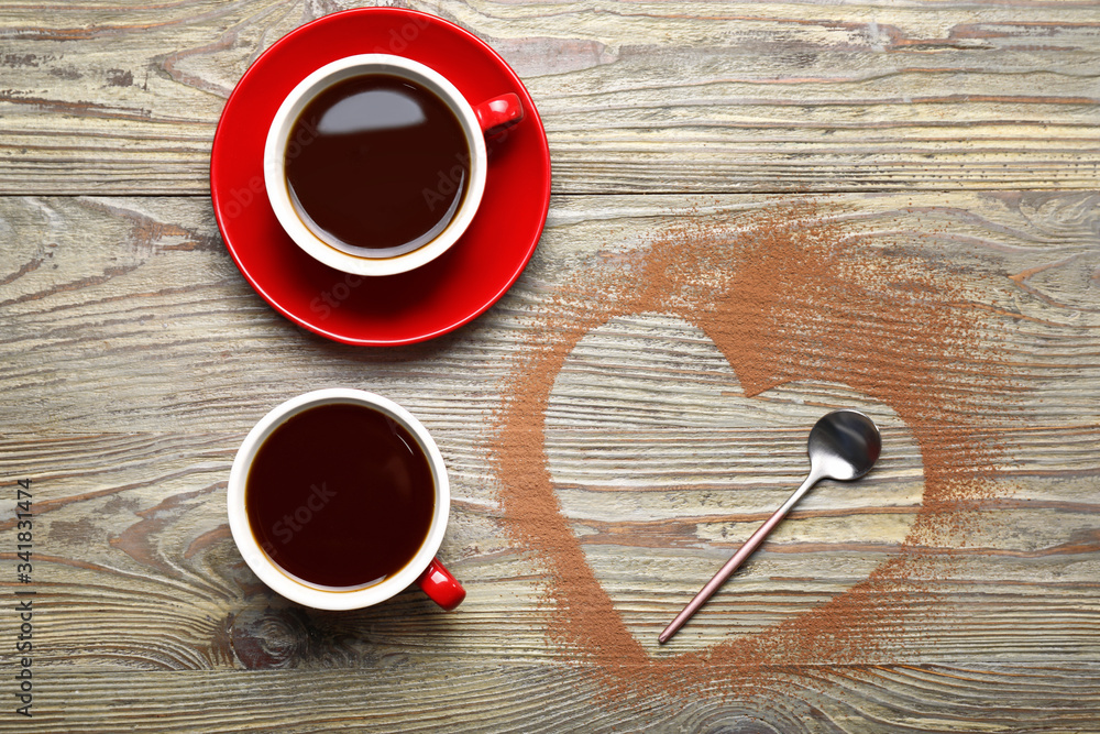 Cups of coffee with heart shape on wooden background