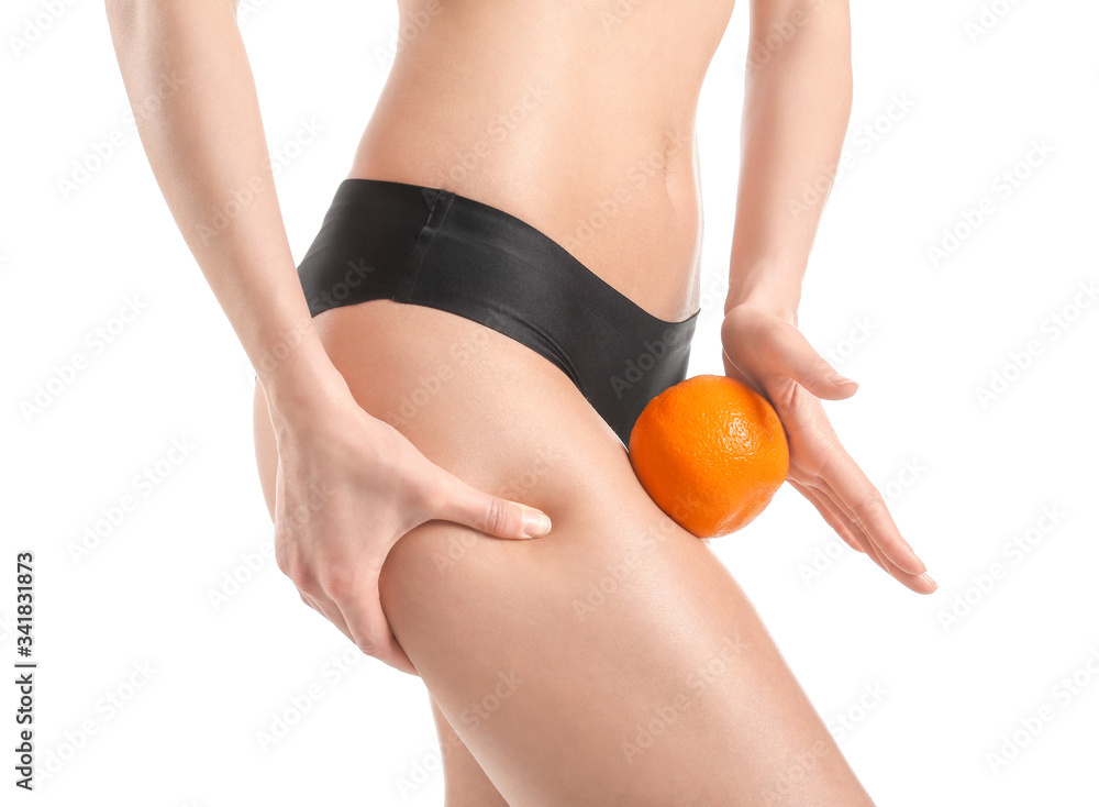 Young woman with orange fruit on white background. Concept of cellulite