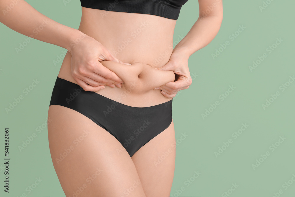 Beautiful young woman in underwear on color background. Concept of cellulite