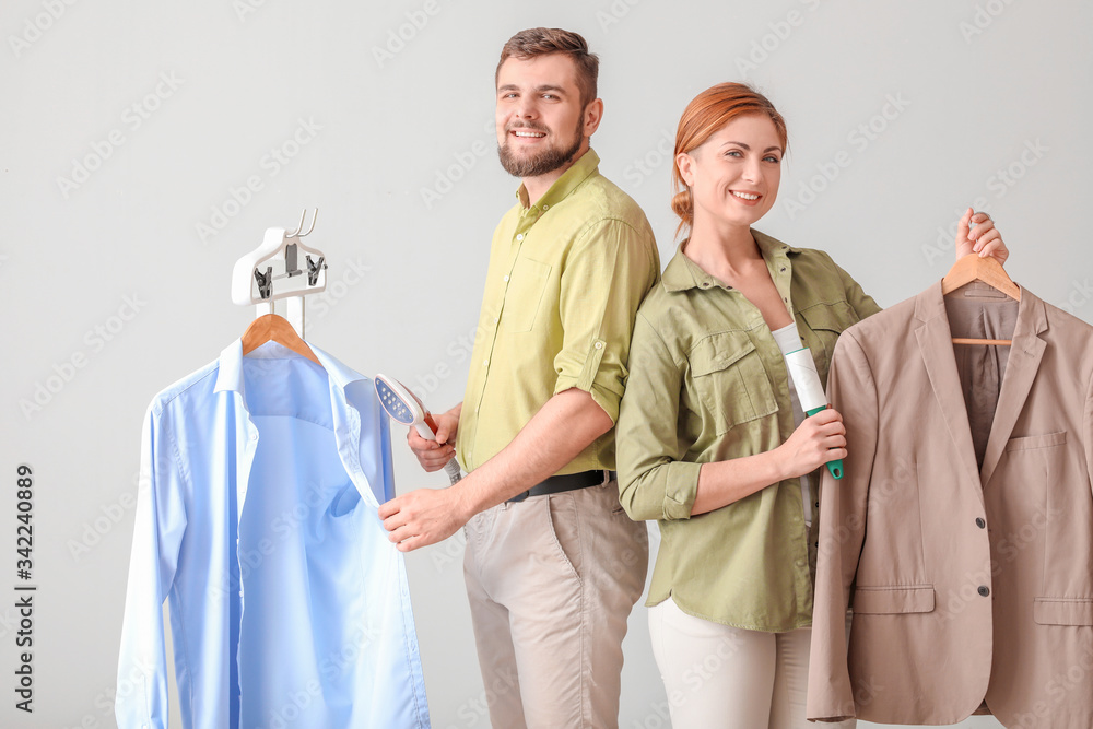 Workers of modern dry-cleaners on light background