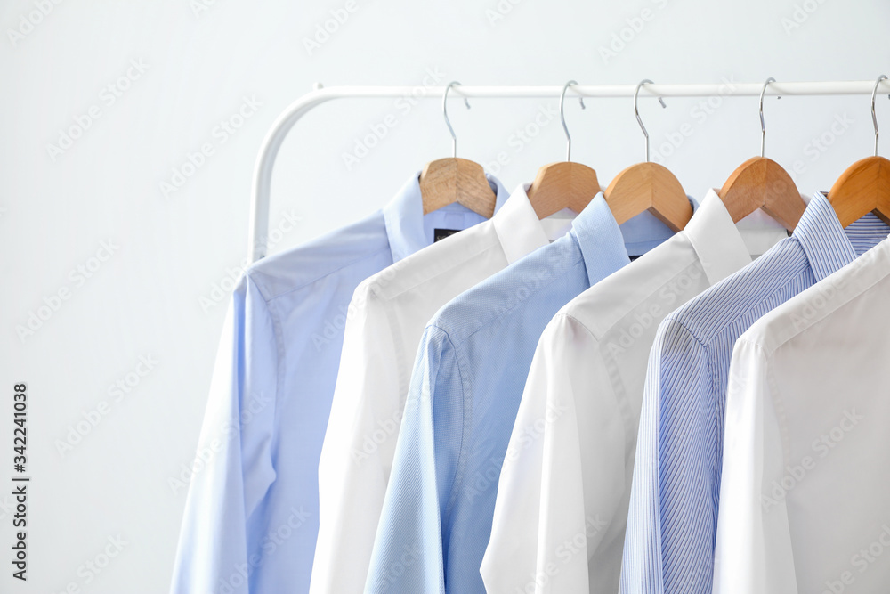 Rack with clothes on light background