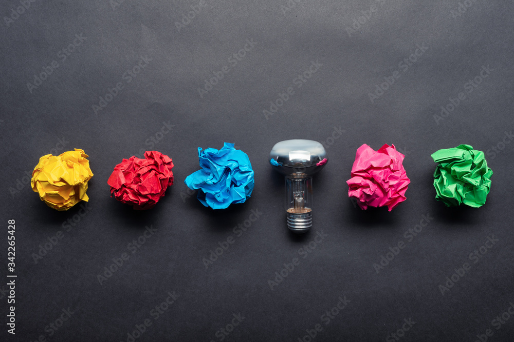 Lightbulb and crumpled colorful paper balls