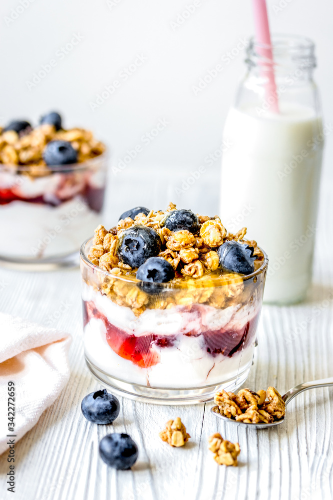 Morning granola with yogurt and berries on white kitchen background