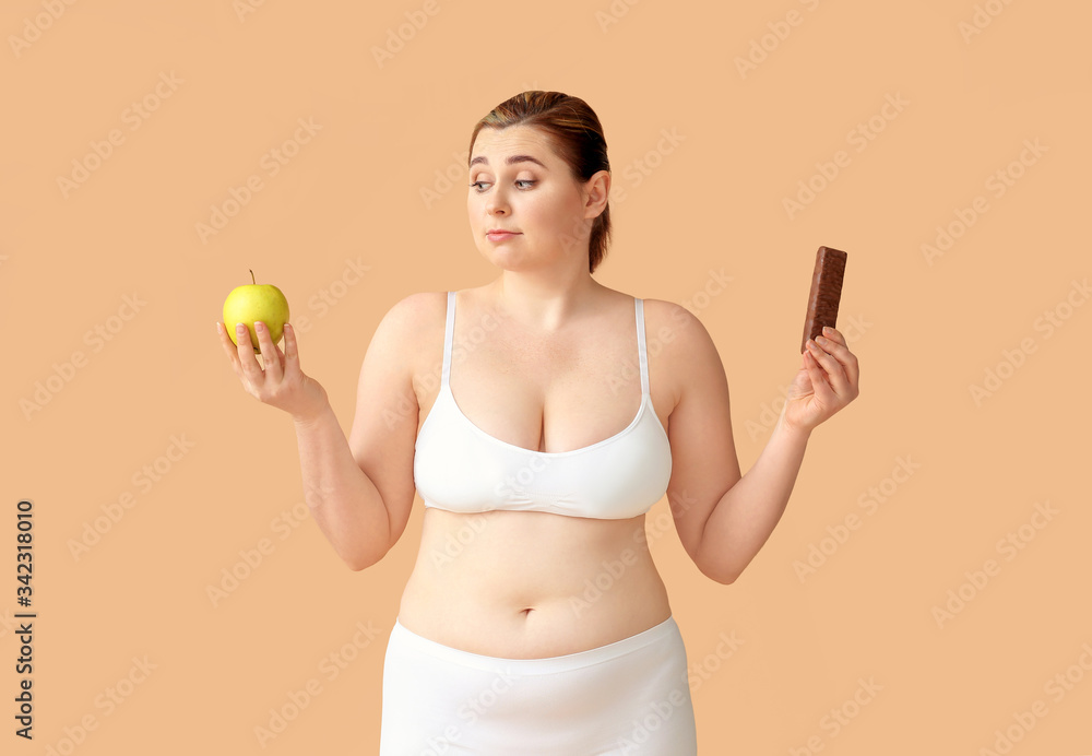 Overweight woman with healthy and unhealthy food on color background. Weight loss concept