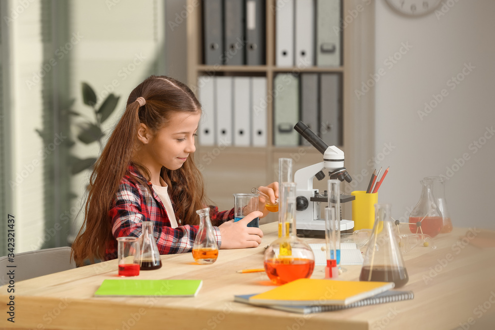 Cute little girl at chemistry lesson in classroom