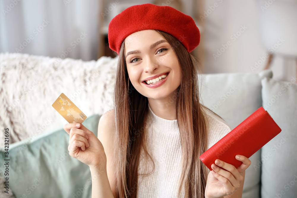 Young woman with wallet and credit card at home. Online shopping concept