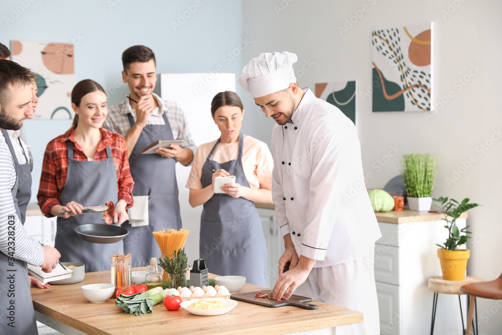 Male chef and group of young people during cooking classes