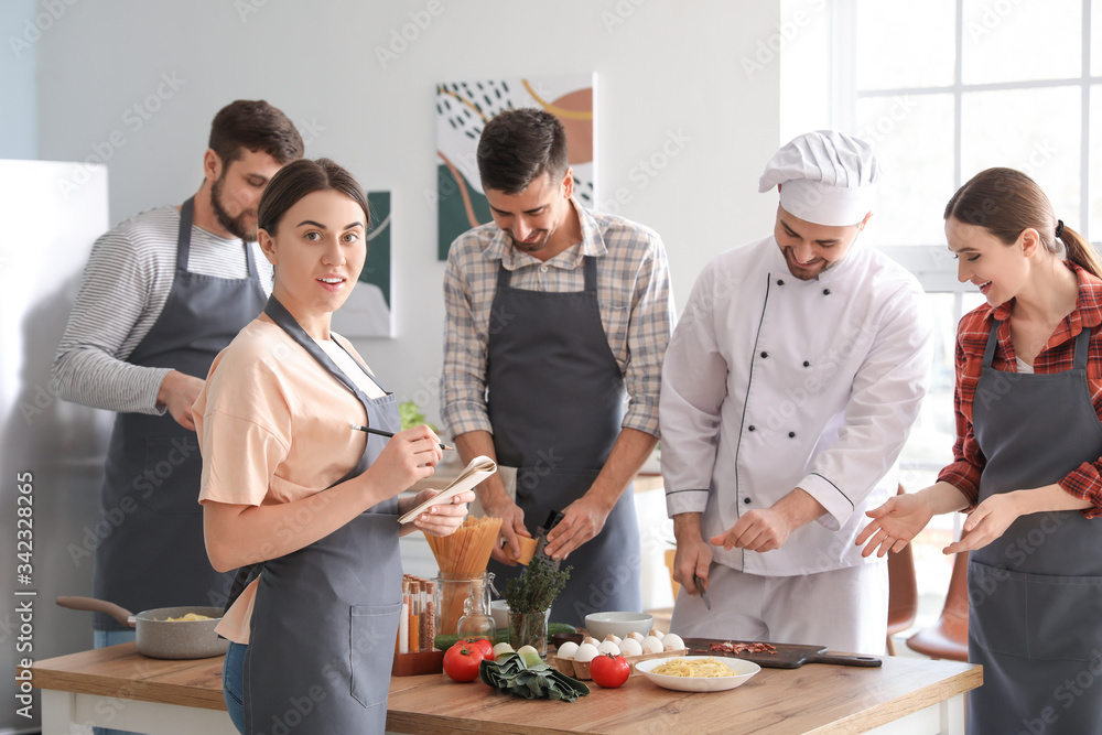 Male chef and group of young people during cooking classes