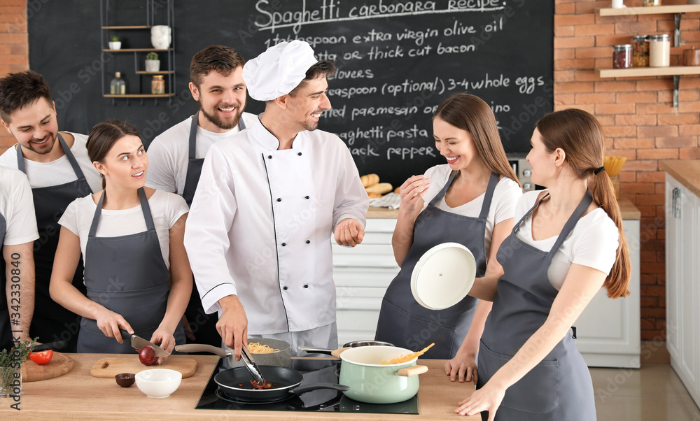 Male chef and group of young people during cooking classes