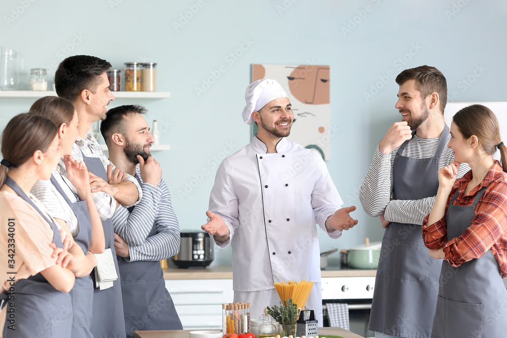 Male chef and group of young people during cooking classes