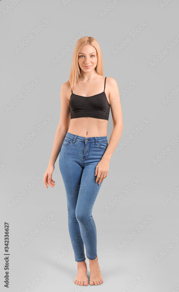 Slim woman on grey background