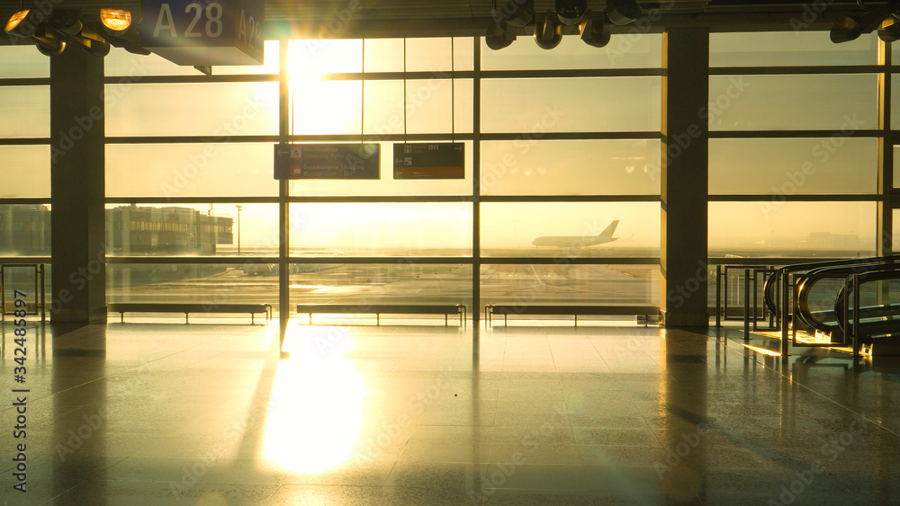 LENS FLARE: Golden morning sunbeams illuminate empty airport terminal at sunrise