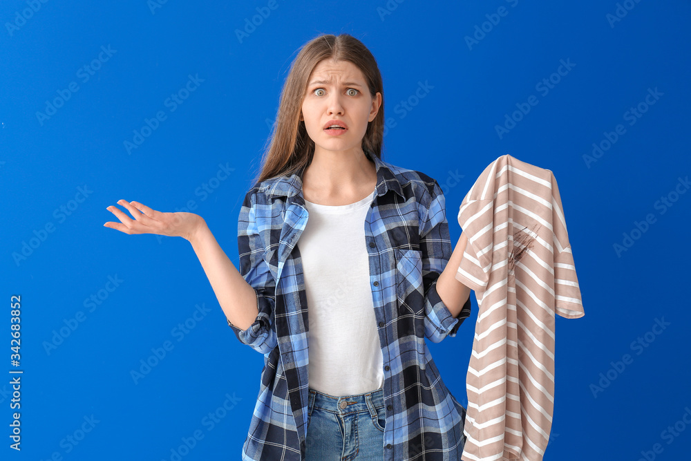 Troubled woman with dirty clothes on color background