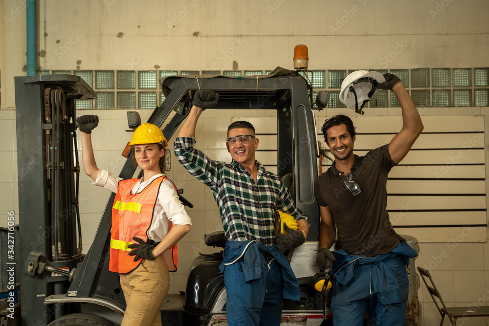 Happy workers working at the machine working with lathe in  in factory.