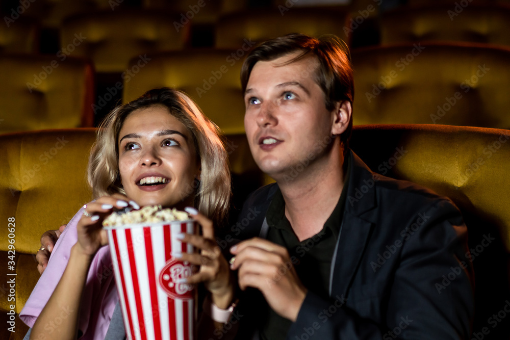 Caucasian lover enjoying to watch movie and eating popcorn together in the cinema