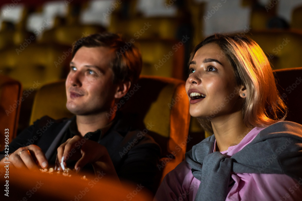 Caucasian lover enjoying to watch movie and eating popcorn together in the cinema