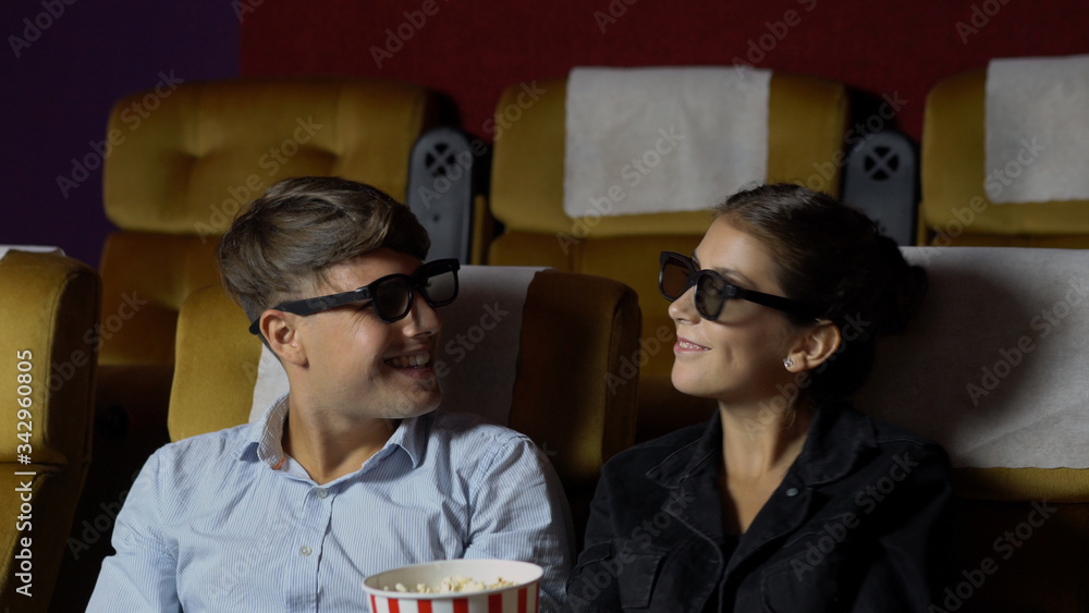 Man and woman in the cinema watching a movie with 3D glasses. with interest looking at the screen, e