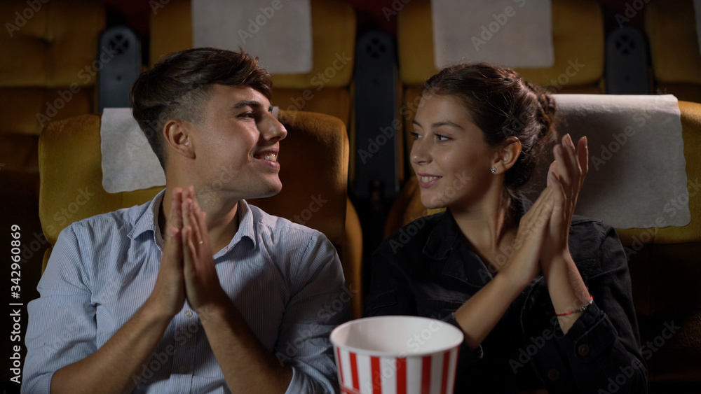 Man and woman applauding enthusiastically at the end of a performance and walk away